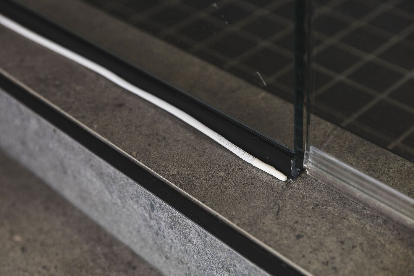 Close-up of the thin PuzL sensing cable lying flat along a floor edge