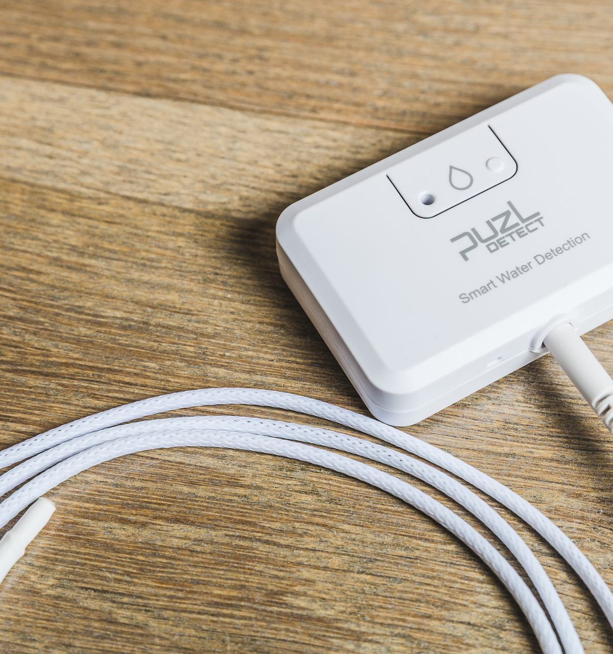 Close-up of a single PuzL Detect unit with its thin, flexible sensing cable